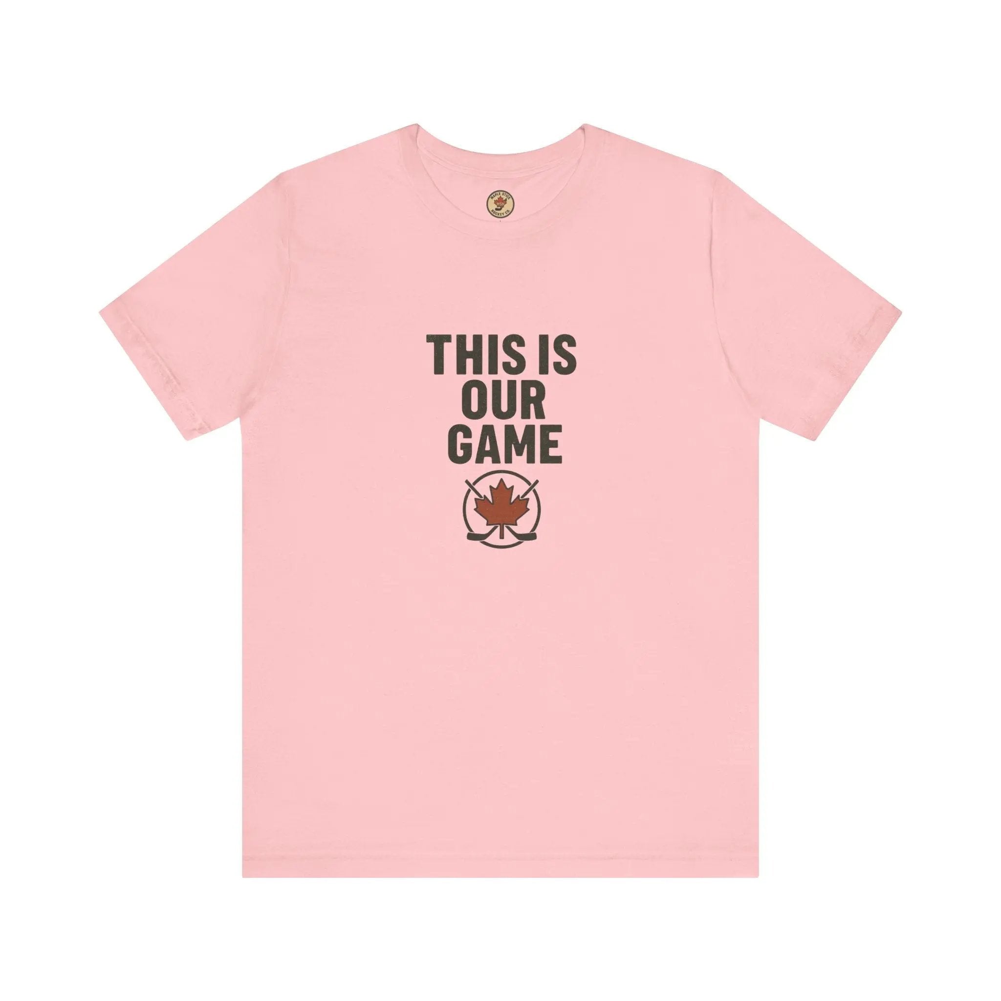 Pink women's T-shirt with 'This Is Our Game' text and maple leaf graphic on a white background