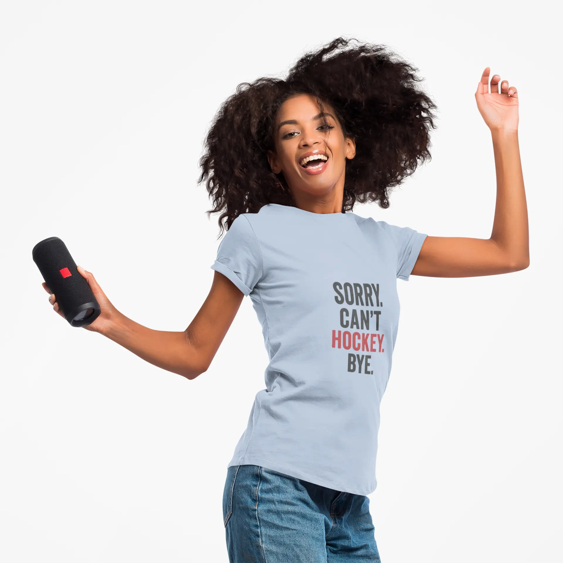 Person wearing light blue 'Sorry. Can't. Hockey. Bye.' T-shirt with red and black lettering, holding a black speaker against white background