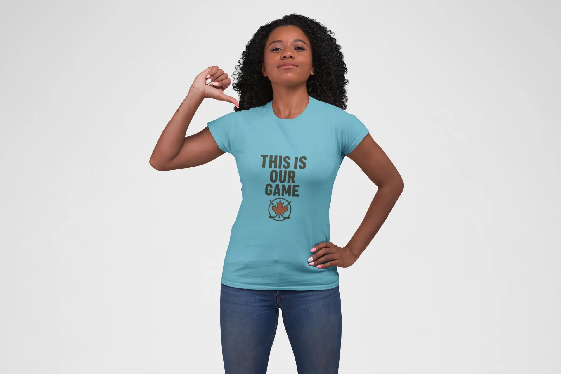 Woman wearing teal 'This Is Our Game' women's t-shirt with maple leaf graphic, raising her arm – Maple Stick Hockey product.